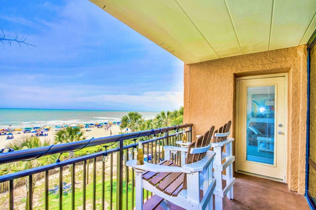 Two balcony lounge seats facing the beach