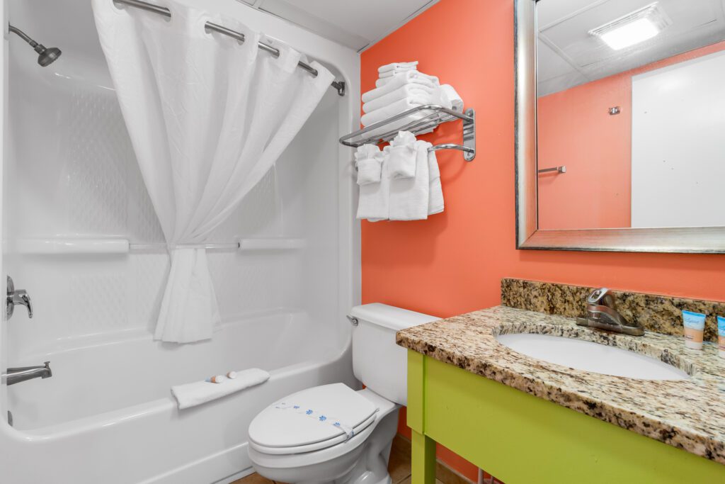 A picture of the white themed bath tub and toilet seat in the bathroom
